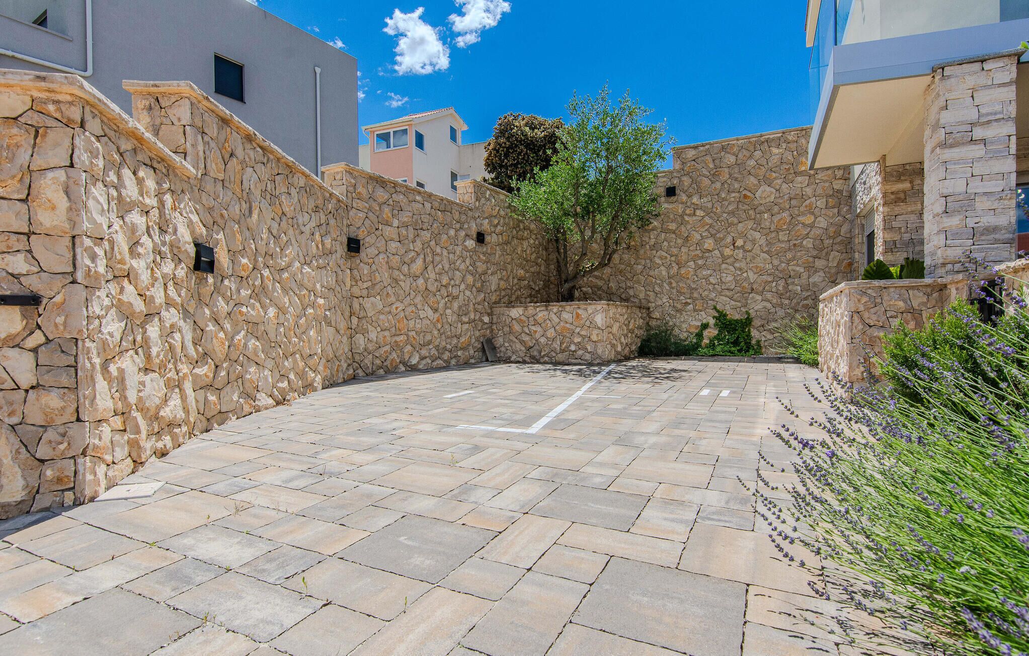 Um pátio com paredes de pedra e piso pavimentado, cercado por edifícios.