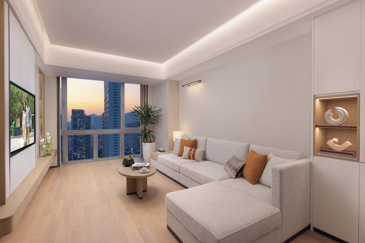 A modern living room with a sofa, coffee table, and a large window offering a city view.