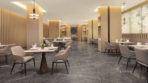 Un restaurant moderne doté d’un sol en marbre, de mobilier contemporain et d’un éclairage d’ambiance.