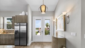 A modern kitchen with stainless steel appliances, a wooden cabinet, and a large window. - Pool Home with Beach Access - Southern Comfort - Roelens (Fort Myers Beach)