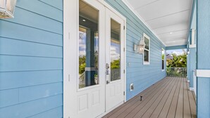 A covered porch with blue siding and a wooden deck. - Pool Home with Beach Access - Southern Comfort - Roelens (Fort Myers Beach)