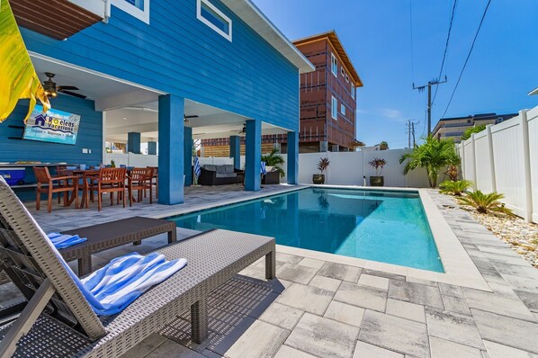 A poolside area with lounge chairs and a covered seating area.