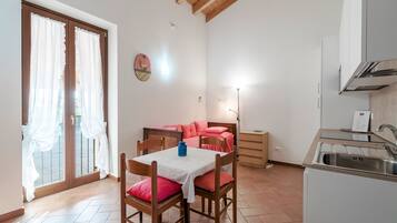 Una cucina compatta con zona pranzo, lavello e tavolo con sedie.