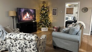 A living room with a fireplace, a Christmas tree, and a television. - Welcome to Rivers Edge Retreat – Your Serene Escape on the Osage River (Jefferson City)