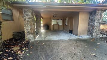 A garage with a concrete floor, stone pillars, and a covered entrance.