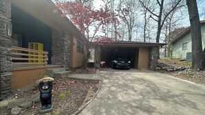 A residential driveway leading to a garage with a parked car. - Cozy cabin in serene Bella Vista with WiFi and AC (Bella Vista)