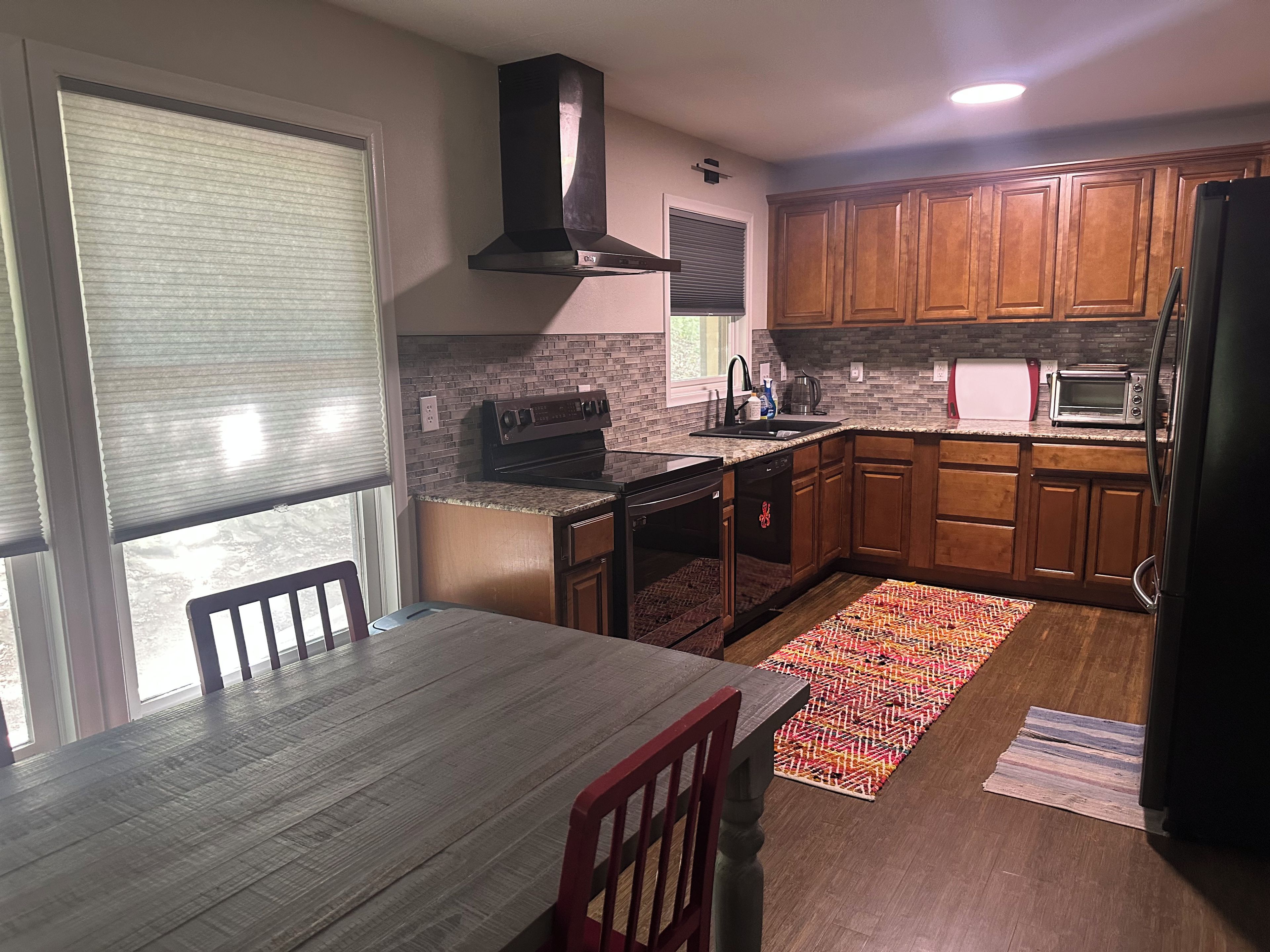 A kitchen with wooden cabinets, a built-in oven, a microwave, and a dishwasher.