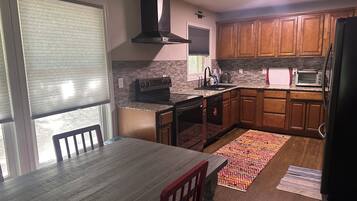 A kitchen with wooden cabinets, a built-in oven, a microwave, and a dishwasher.