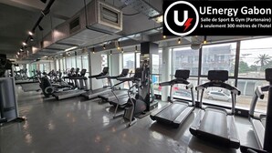 A gym with treadmills, elliptical machines, and weight equipment. - Roma Hôtel & Restaurant (Libreville)