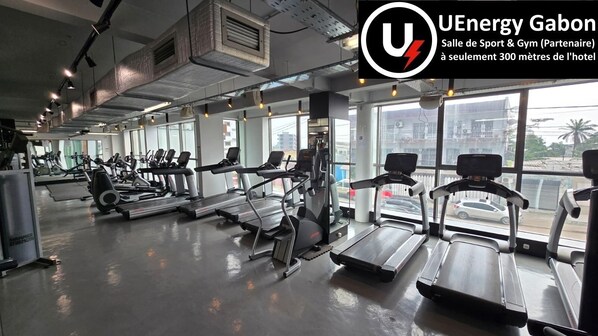 A gym with treadmills, elliptical machines, and weight equipment. - Roma Hôtel & Restaurant (Libreville)