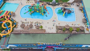 A water park with multiple slides and pools, a pirate ship play area, and a sign reading "TSUNAMI". - Roma Hôtel & Restaurant (Libreville)
