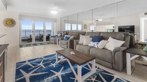 Un salon moderne avec un canapé, une table basse et une vue sur l’extérieur.