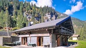 Un chalet doté d’une façade en pierre, de poutres en bois et d’un toit à pente.