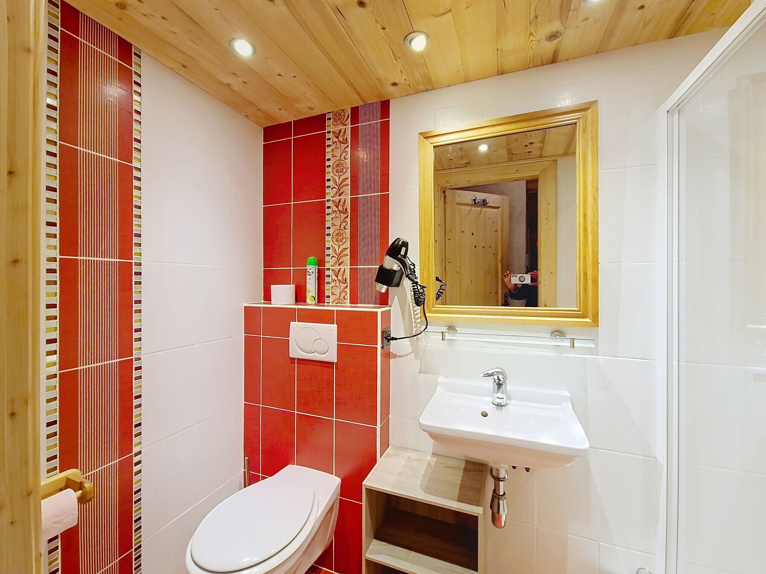 A bathroom with a toilet, sink, and mirror.