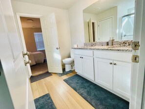 A bathroom with a toilet, sink, and cabinets. - Spacious 5-bedroom house with WiFi and AC in charming Winston-Salem (Winston-Salem)