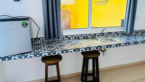 Eine Küche mit Fenster, zwei Barhocker und einem Spülbecken.