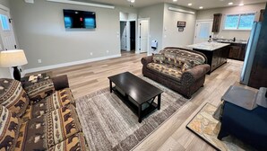 A spacious living room with a sofa, coffee table, and a ceiling fan. - Charming cabin with WiFi - perfect for a cozy getaway (Smoot)