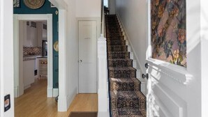 Un escalier recouvert d’une moquette à motifs menant à une porte sur laquelle est inscrit « TOILETTES ».