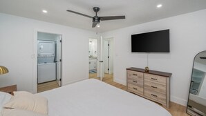 A bedroom with a bed, a dresser, a TV, and a ceiling fan. - Sunny Haven #623: 1BR Townhome in Fort Walton (Fort Walton Beach)