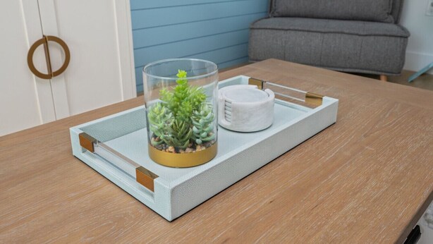 A clear glass terrarium with succulents on a tray with a white mug beside it, placed on a wooden table. - Sunny Haven #623: 1BR Townhome in Fort Walton (Fort Walton Beach)