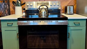 Una cocina con una campana extractora de acero inoxidable, un horno empotrado y un tostador.