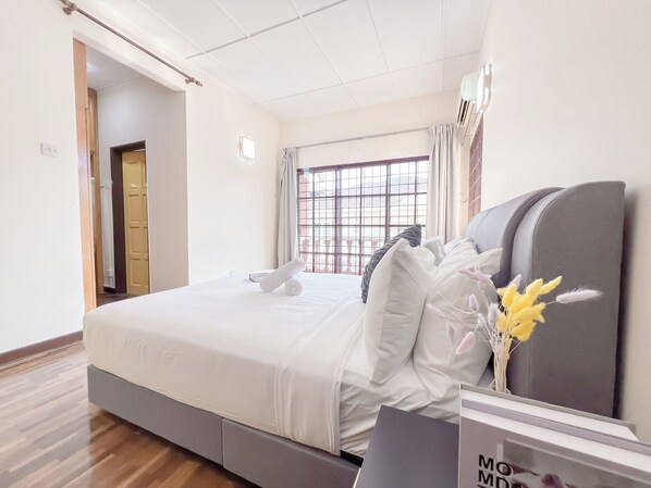 Relax in a clean and modern room with a comfortable bed, bedside table, and large window.
