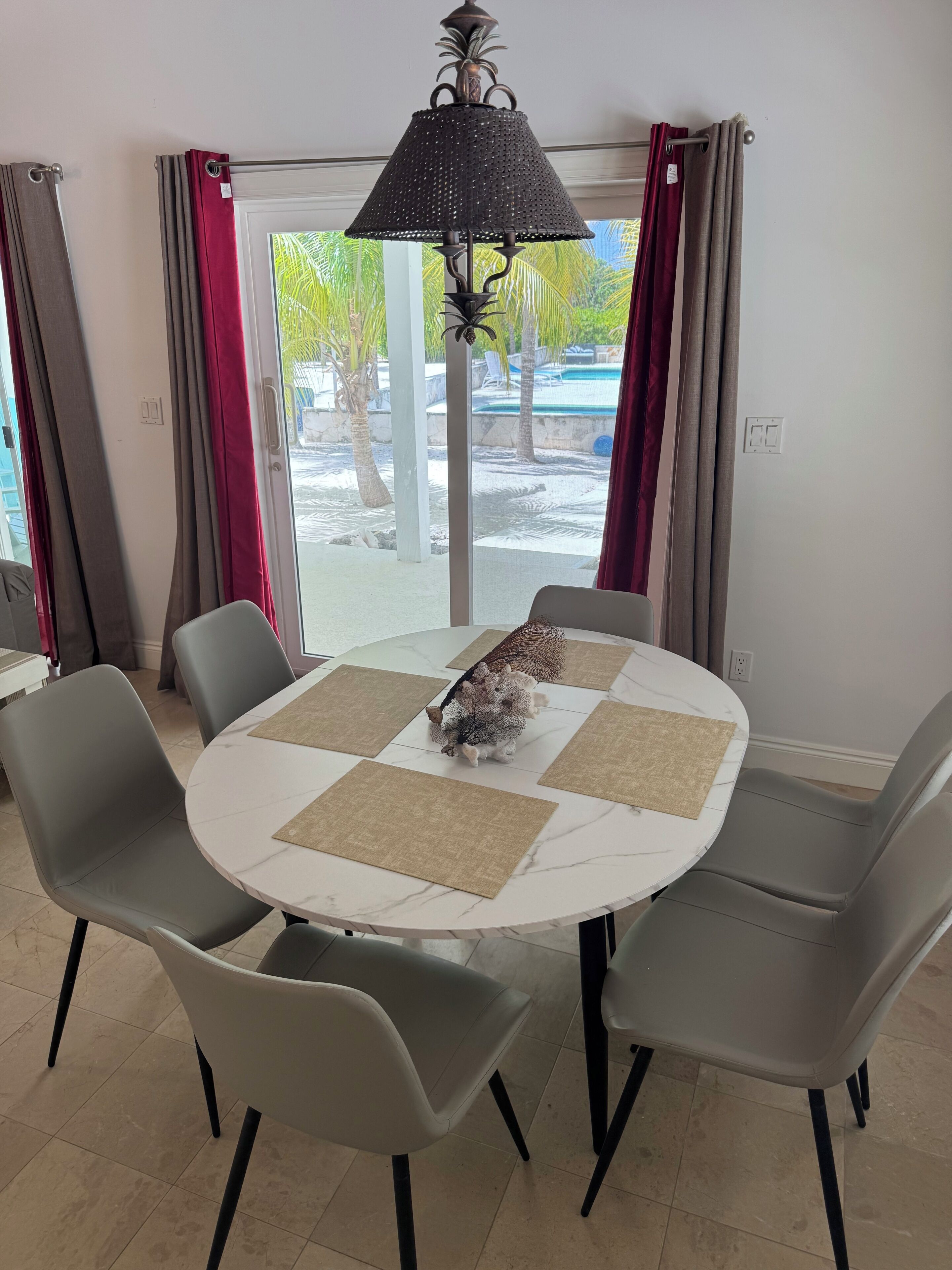 Un coin repas avec une table ronde, des chaises grises et une lampe décorative.