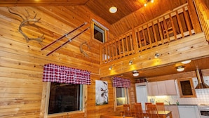 A cozy cabin interior with wooden walls, a dining area, and a kitchen. - Villa kunteus by Interhome (Raattama)