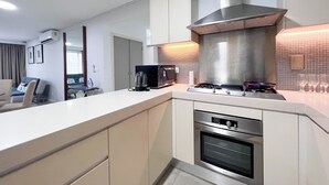 A modern kitchen with a built-in oven, a gas stove, and a stainless steel range hood.