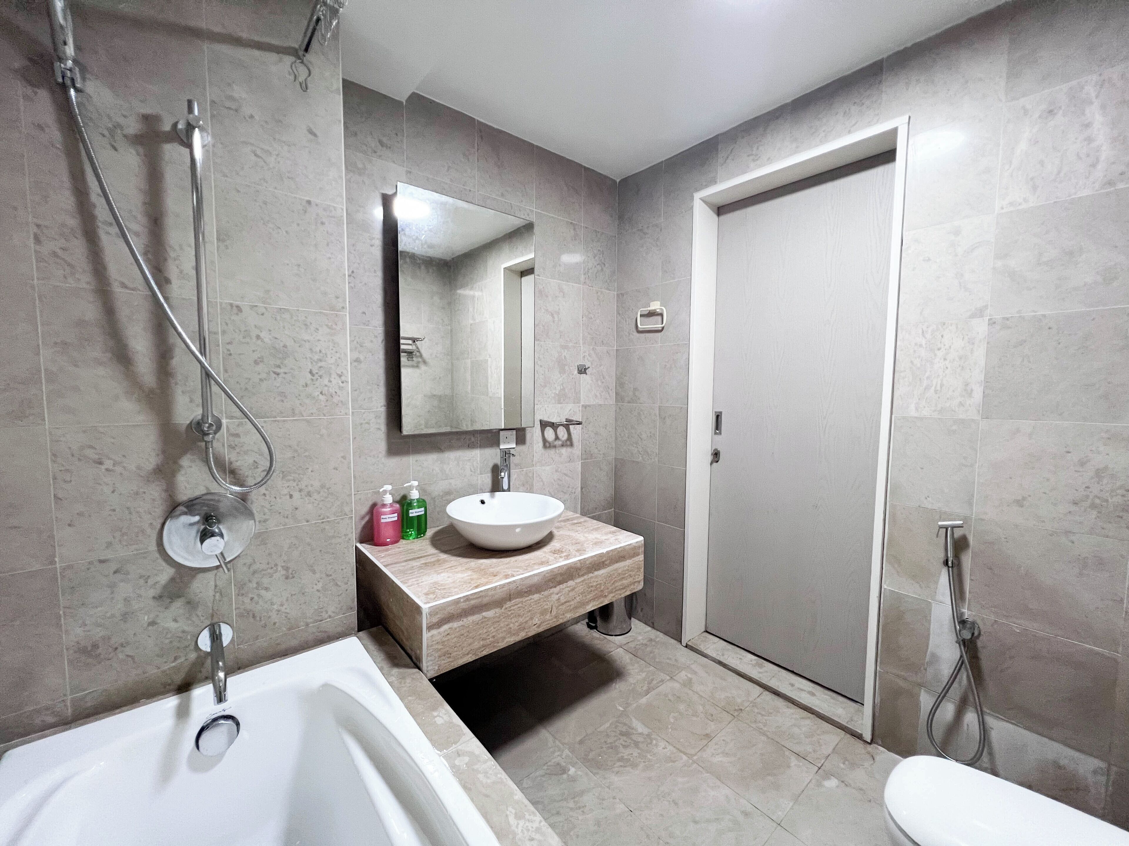 A modern bathroom with a bathtub, a sink, a mirror, and a shower.