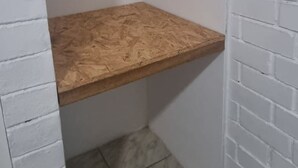 A small, enclosed room with a wooden shelf and a metal rod. - Hermosa casa en playa pulpos, cerca de las playas, comercial KM40 . (Punta Hermosa)