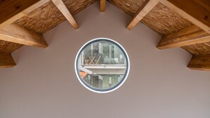 A circular window with a view of a balcony and a building outside. - GuestReady - Silk Factory - B (Porto)