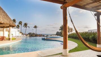 Alberca al aire libre, sombrillas en la alberca y camastros