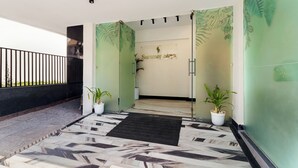 A hotel entrance with a modern design, featuring a patterned floor, potted plants, and a glass door with a 'Summer Stays' sign. - The Keys By Unique Choice Hotels (Udaipur)