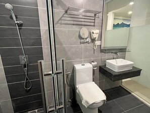 A modern bathroom with a shower, toilet, sink, and towel rack.
