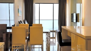 A modern hotel room with a dining area, large windows, and a flat-screen TV. - Grand Ion Delemen by Manhattan Group (Genting Highlands)