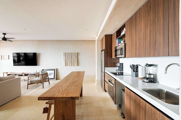 Una cocina moderna con armarios de madera, un lavamanos de acero inoxidable y un horno empotrado.