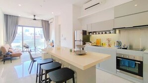 A modern kitchen with a central island, built-in appliances, and a dining area with a sofa and chairs.