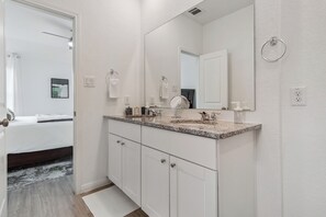 A bathroom with a double sink vanity, a large mirror, and a towel rack. - Cozy and Modern, 3 bedroom, 2 bathroom Home in Converse, TX/Near San Antonio. (Converse)