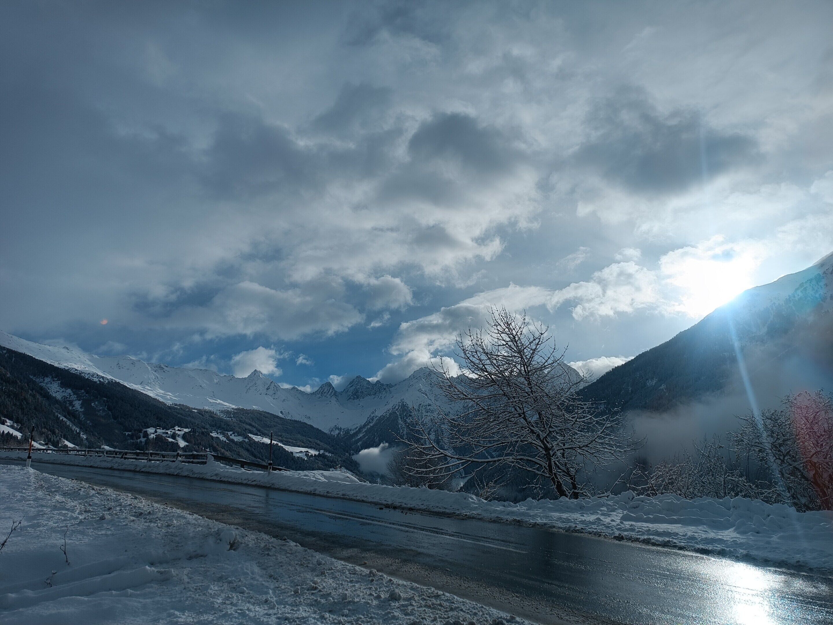 A snowy landscape with mountains, a river, and a clear sky.