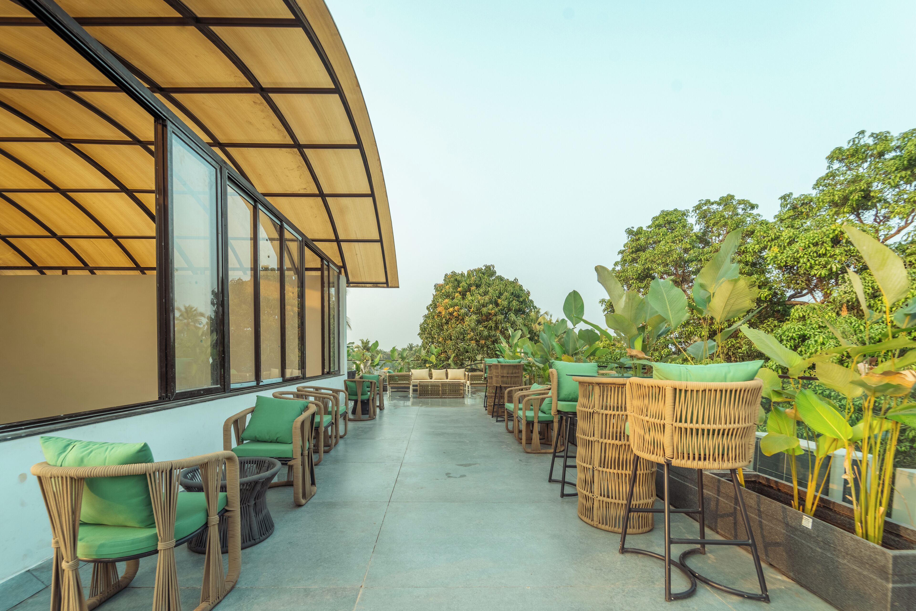 An outdoor seating area with wicker furniture and potted plants.