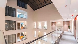 A multi-level interior with glass railings, potted plants, and a modern design. - Vilmaris Luxury Hotel in Calangute (Calangute)