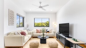 A modern living room with a sofa, coffee table, and TV.