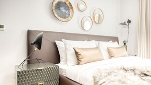 Ein ordentlich eingerichtetes Schlafzimmer mit Bett, Nachttischen und Wanddekoration.