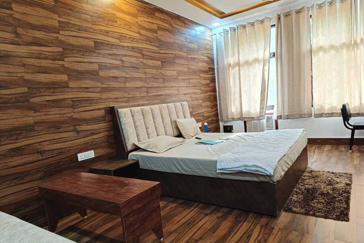 Ein Schlafzimmer mit Holzwand, einem Bett, einem Nachttisch und einem Sessel.