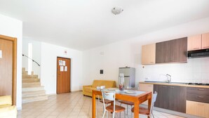 Un appartement moderne comprenant un coin repas, une cuisine et un escalier menant à l’étage supérieur.