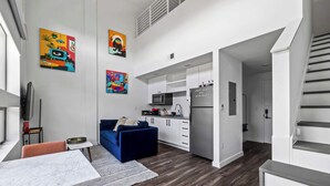 Eine moderne Wohnung mit Wohnbereich, Küche und Treppe.