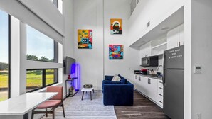 Eine moderne Küche mit Essbereich, großen Fenstern und Kunstwerken an den Wänden.