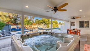 A hot tub area with two ceiling fans, a patio with outdoor seating, and a view of a themed landscape. - Rio Resort (Scottsdale)