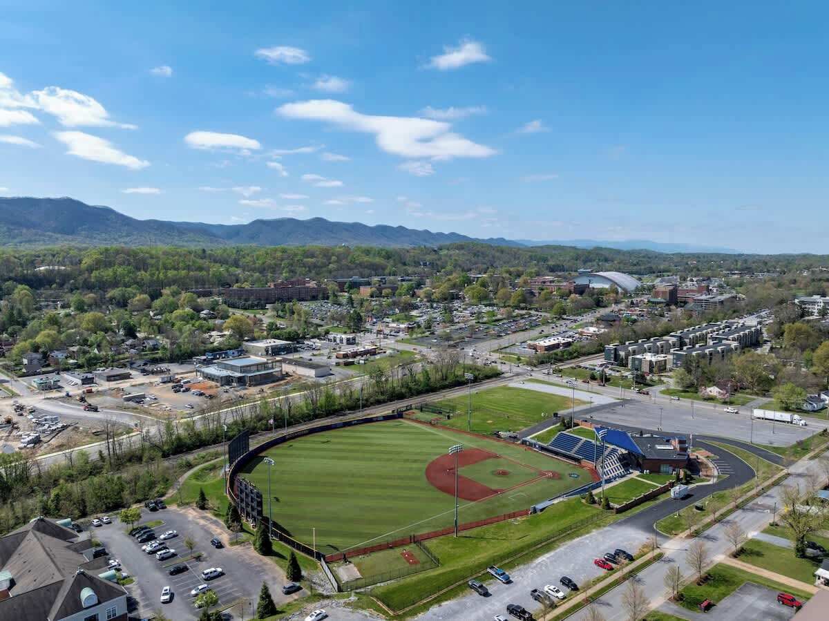 Vue aérienne d’un terrain de baseball entouré de bâtiments et de routes.